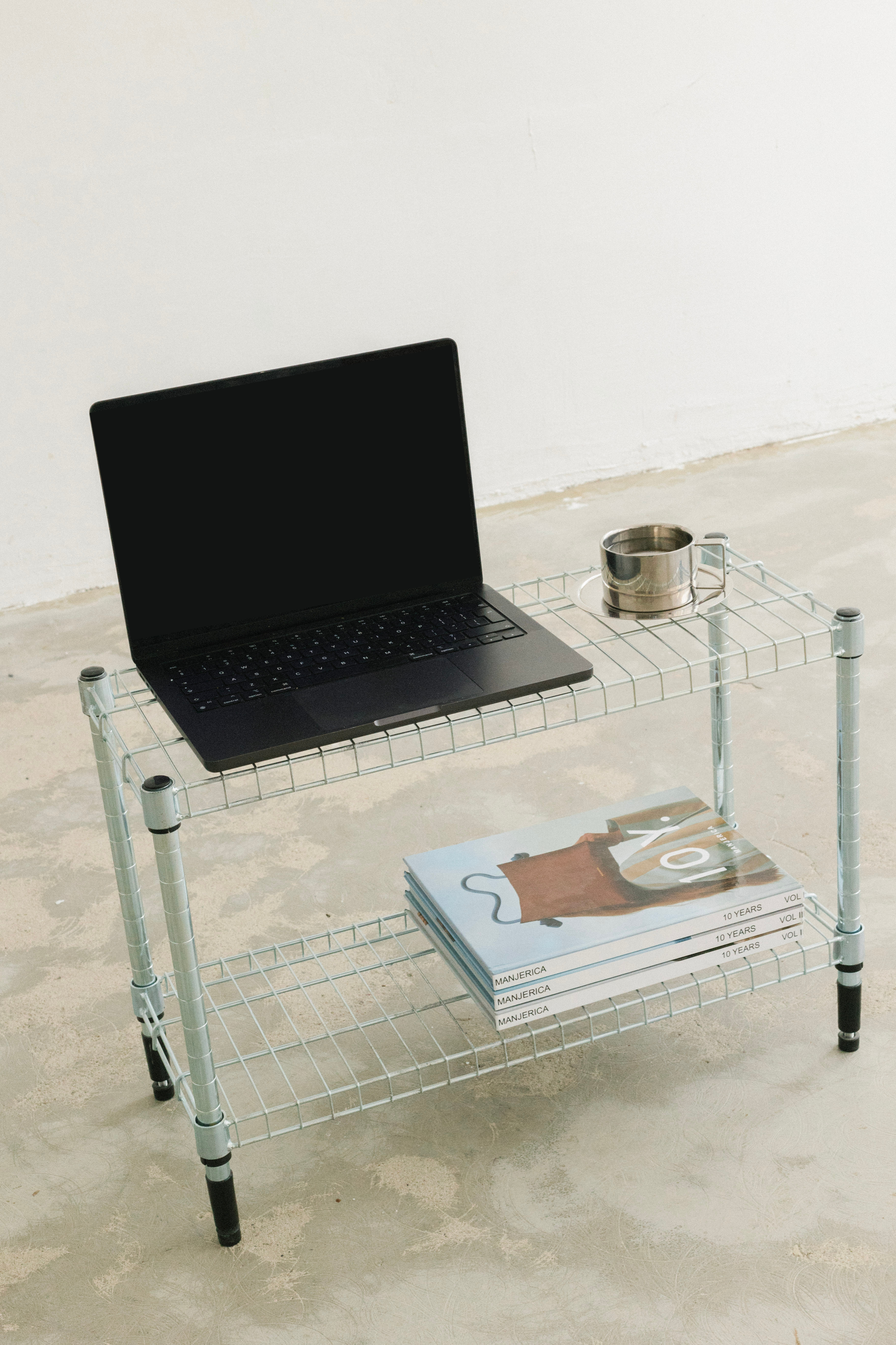 MacBook of a web designer standing on a table with magazines