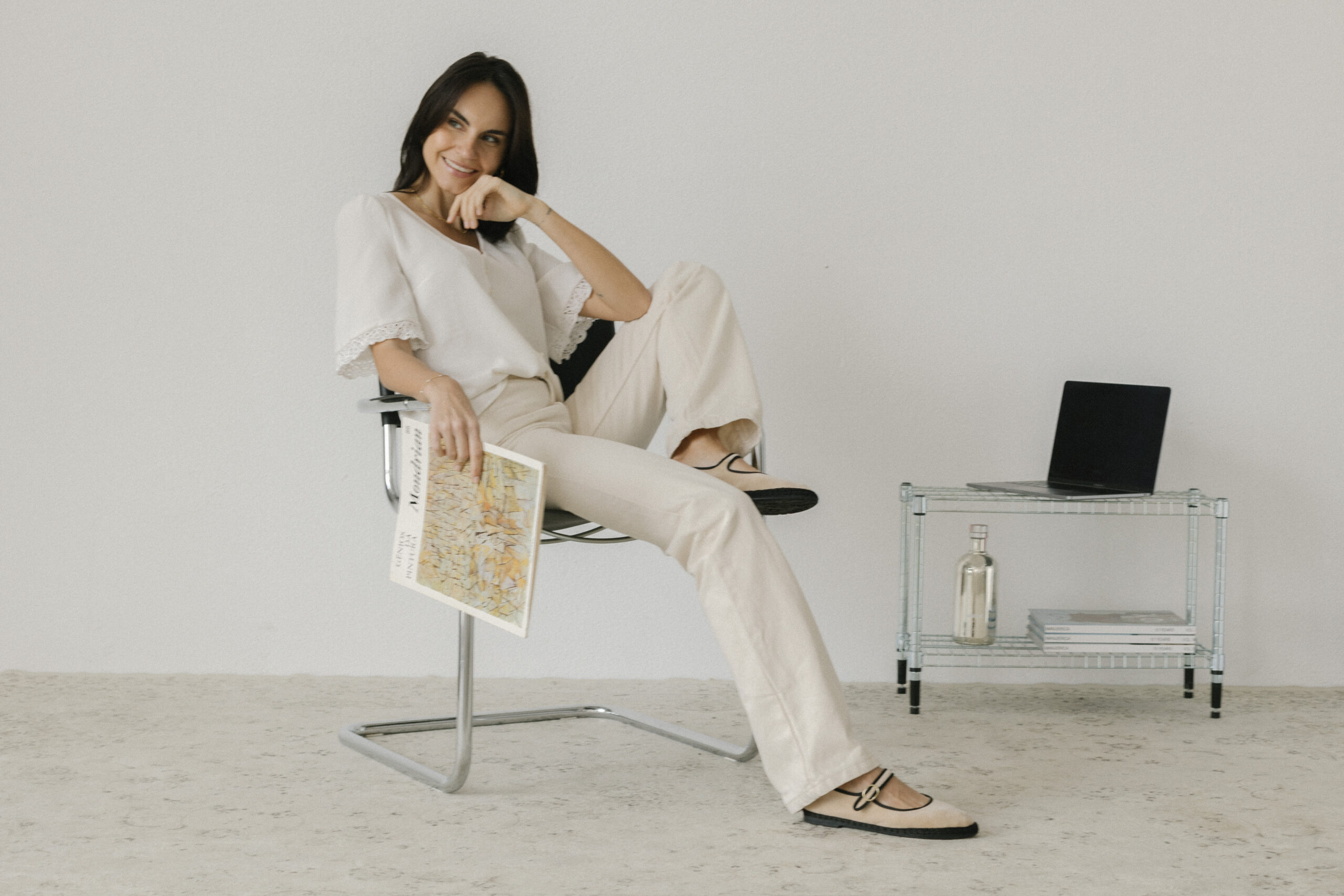 Brand and web designer sitting on chair with macbook and magazine